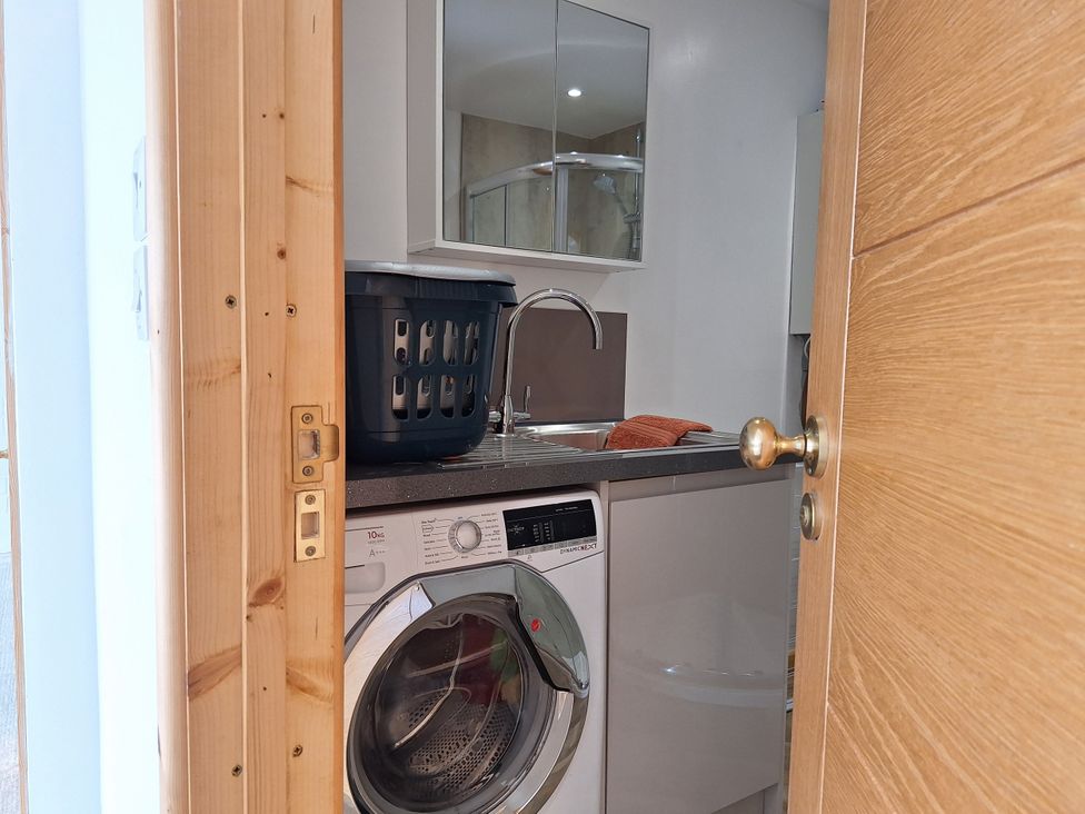 A laundry room with a washing machine and sink at The Halt in Maiden Newton