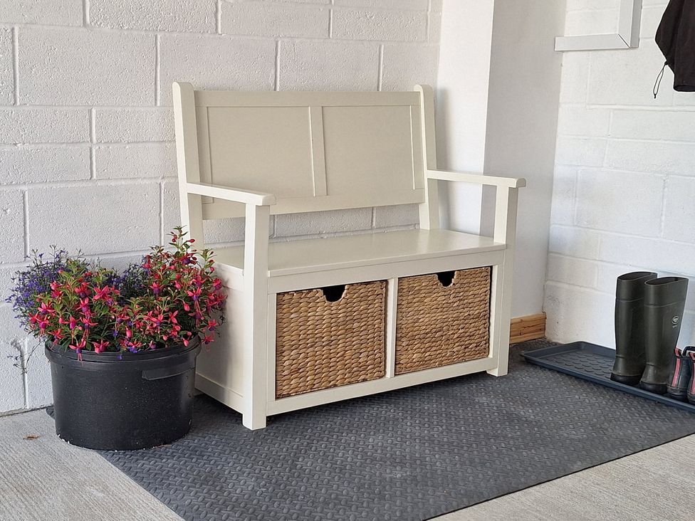 An entryway with a bench and flower planter at The Halt in Maiden Newton