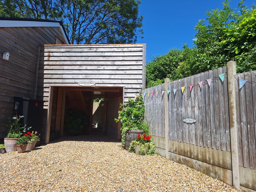 An outdoor area with gravel and a wooden building at The Halt in Maiden Newton