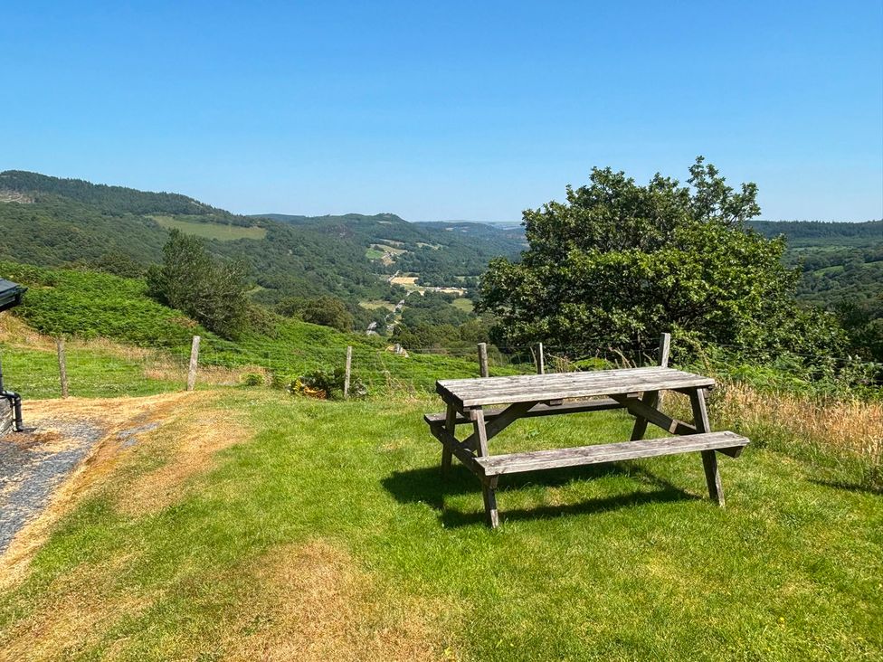 An outdoor area with a picnic table and green grass at Ty Llugwy in Capel Curig near Betws-Y-Coed