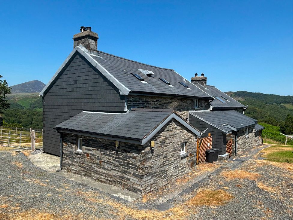 A house with a stone wall and slate roof at Ty Siabod Capel Curig near Betws-Y-Coed