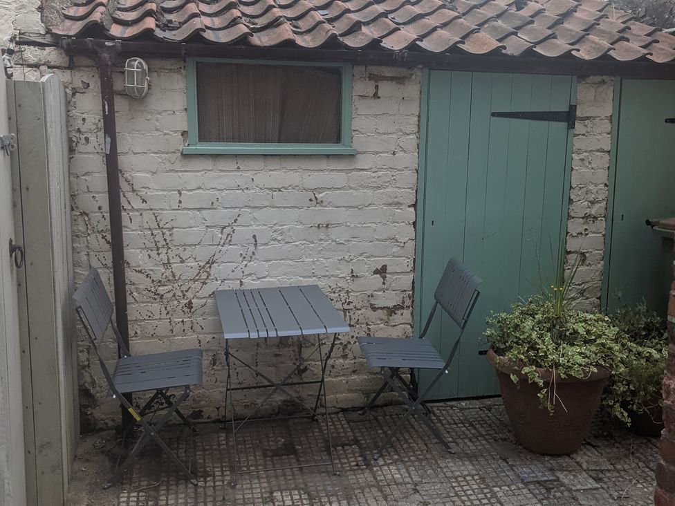 A garden with a table and chairs beside a wall at 174 High Street, Marske-By-The-Sea