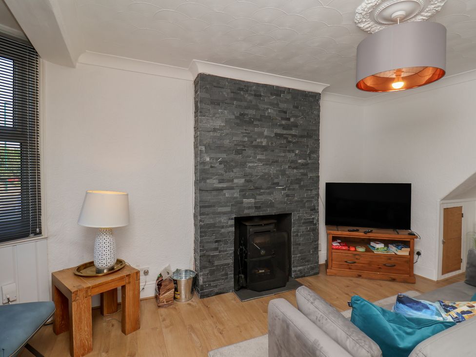 A living room with a stone fireplace and television at 174 High Street in Marske-By-The-Sea