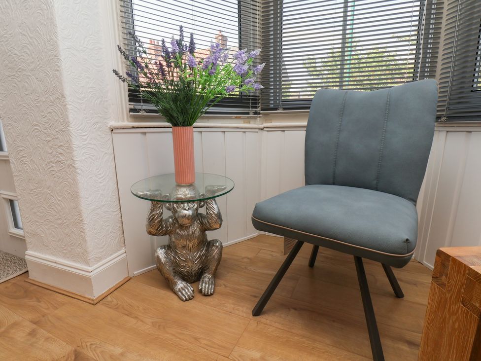 A snug with a plant on a glass table and a chair at 174 High Street, Marske-By-The-Sea