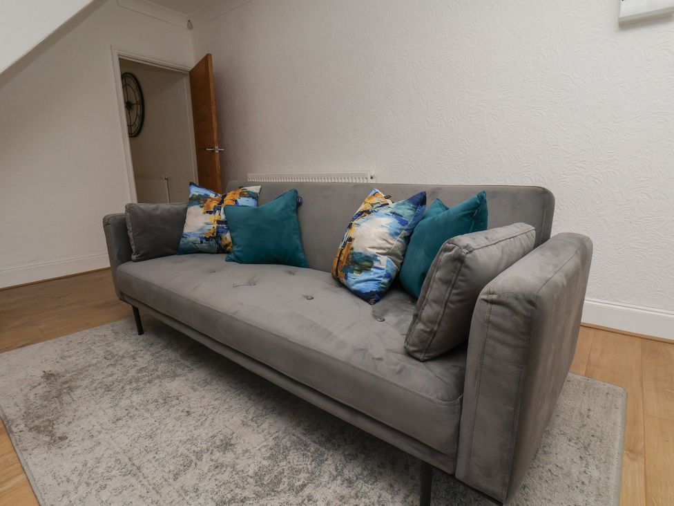 A living room with a grey sofa and cushions at 174 High Street, Marske-By-The-Sea