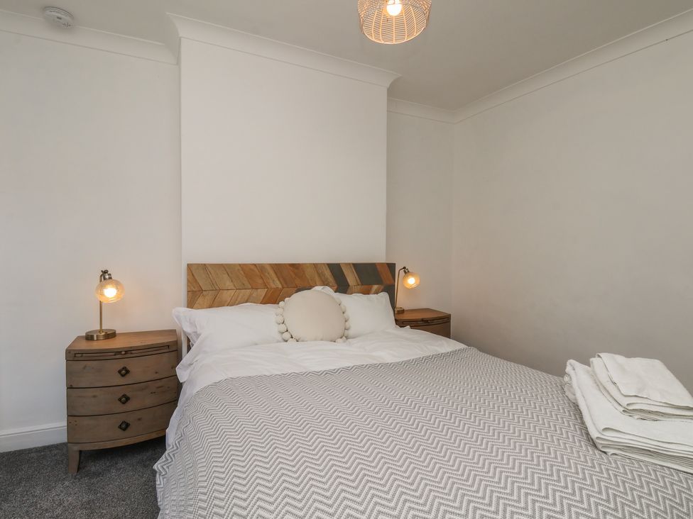 A bedroom with a bed and nightstand at 174 High Street in Marske-By-The-Sea