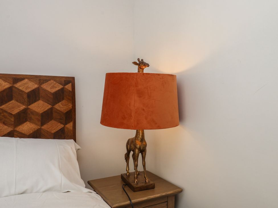 A bedroom with a lamp on a nightstand at 174 High Street Marske-By-The-Sea