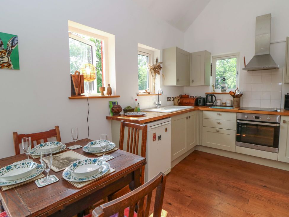 A kitchen with a dining table set for a meal at Delfryn in Llandeilo