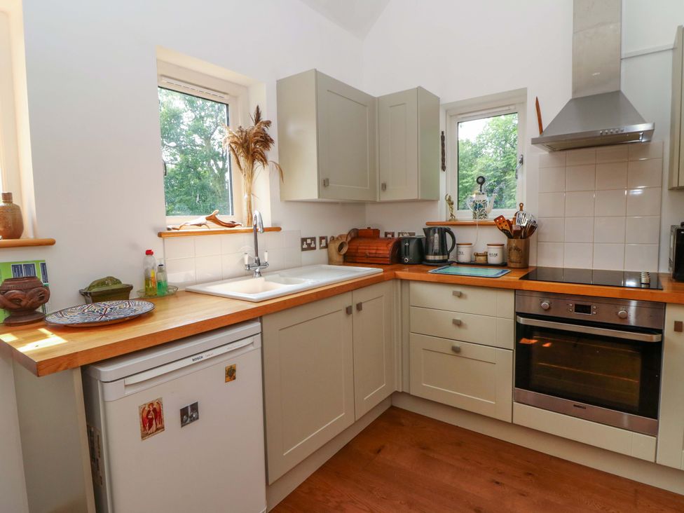 A kitchen with a sink and appliances at Delfryn in Llandeilo