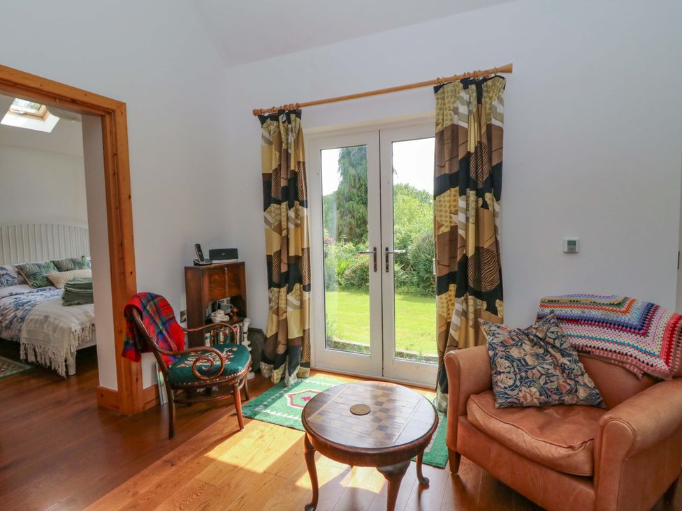 A living room with a door leading to the garden at Delfryn in Llandeilo