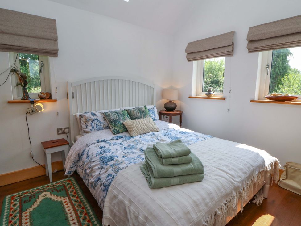A bedroom with a bed and pillows at Delfryn in Llandeilo