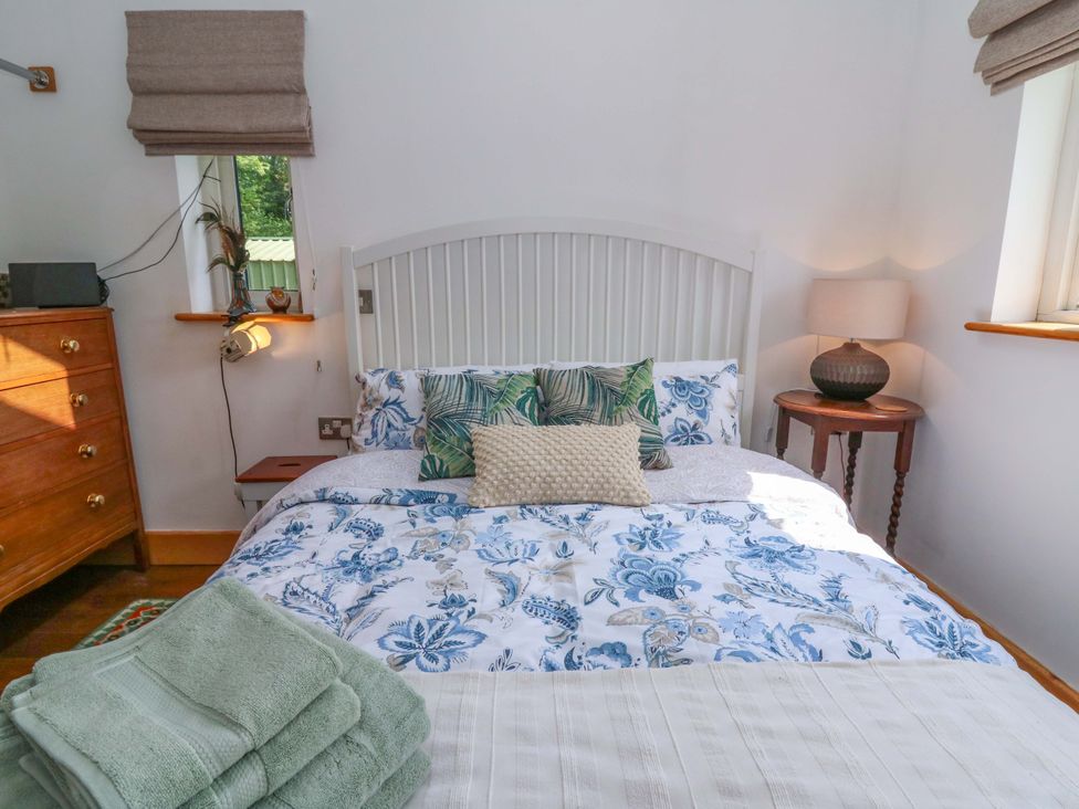 A bedroom with a bed and bedside table at Delfryn in Llandeilo