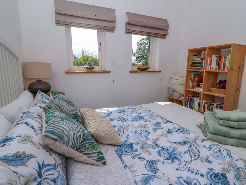 A bedroom with a bed and bookshelf at Delfryn in Llandeilo