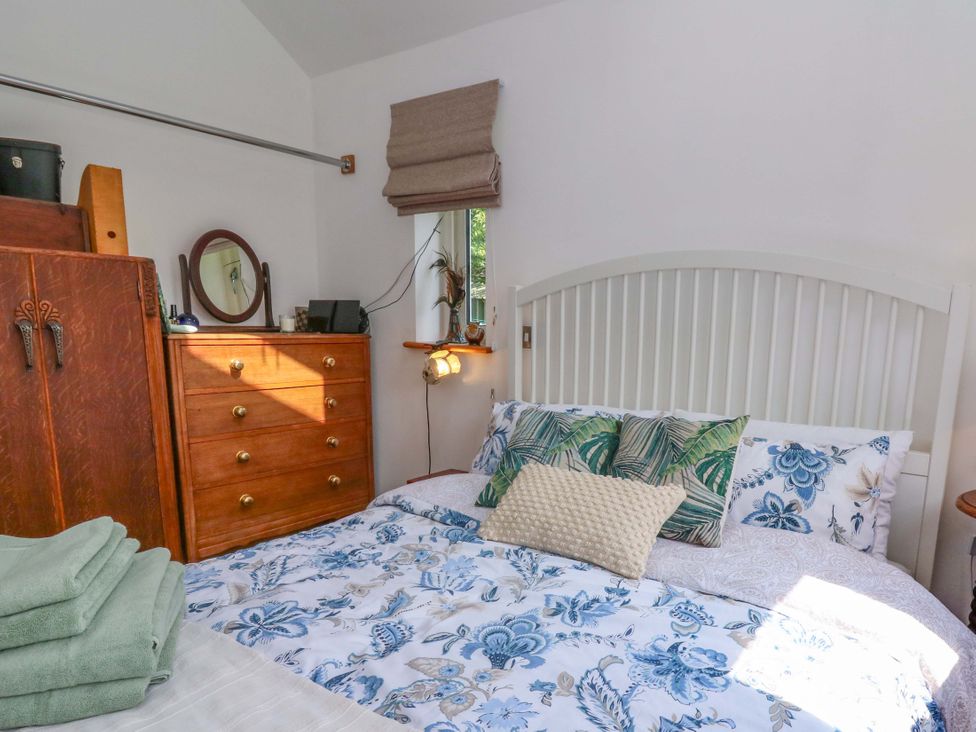 A bedroom with a bed and wooden furniture at Delfryn in Llandeilo