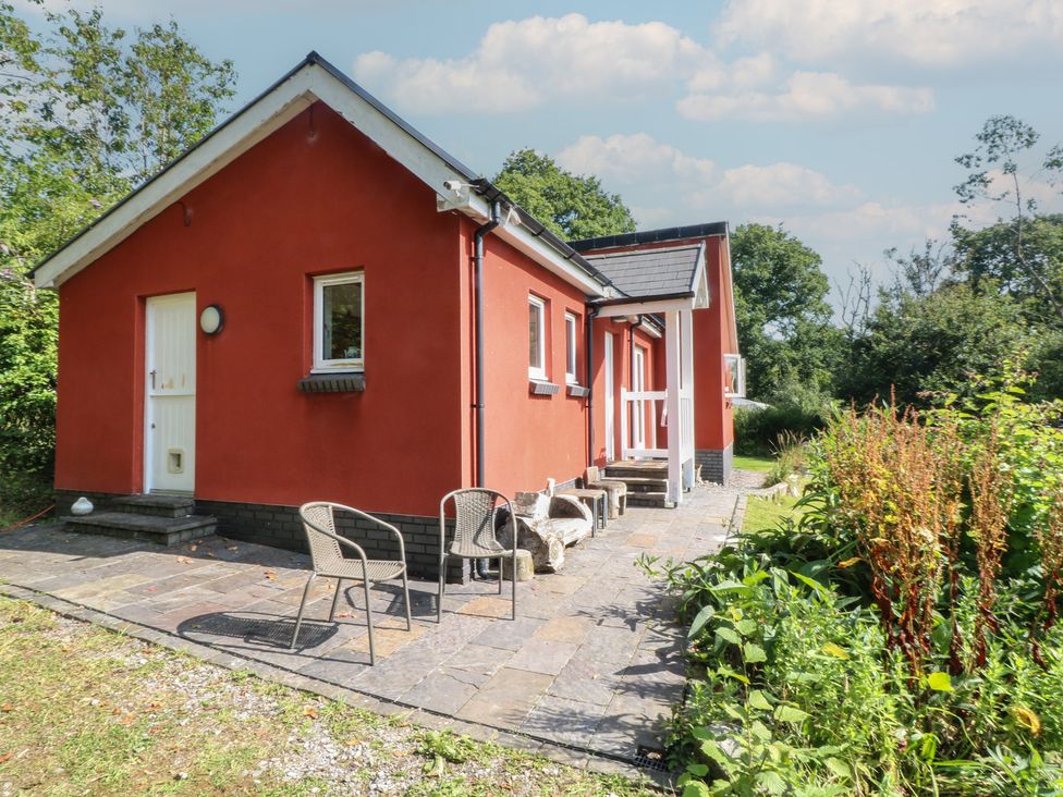 A red house with a patio and chairs at Delfryn Llandeilo near Llandeilo