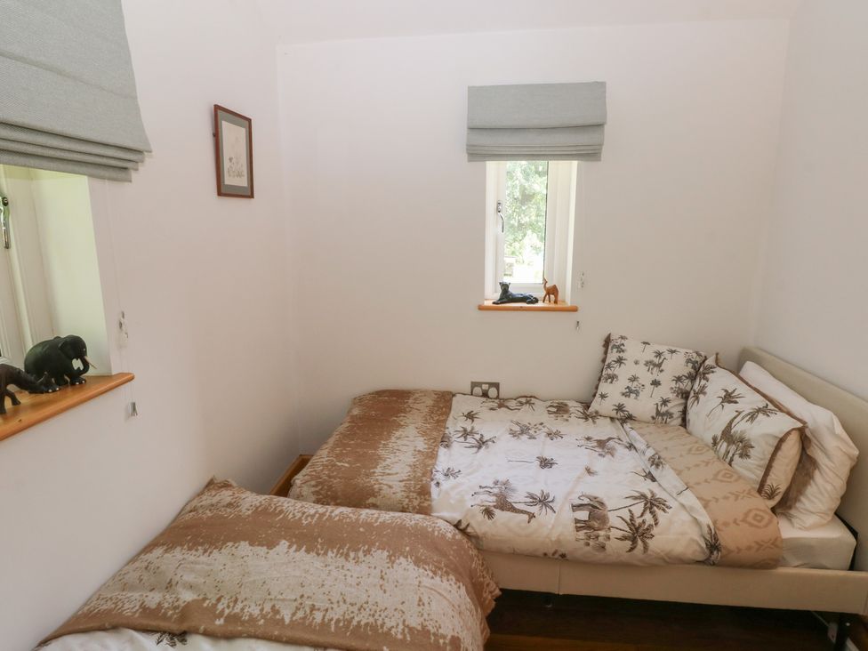 A bedroom with two beds and animal figurines at Delfryn Llandeilo near Llandeilo