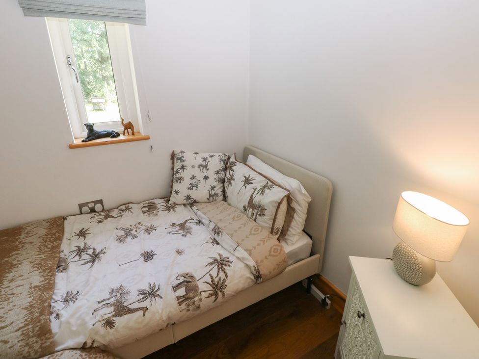 A bedroom with a bed and lamp at Delfryn Llandeilo near Llandeilo