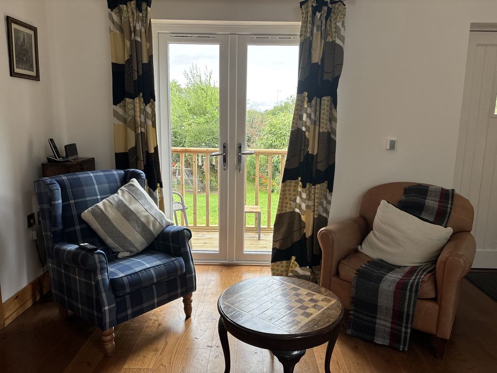 A living room with an armchair and table at Delfryn Llandeilo near Llandeilo