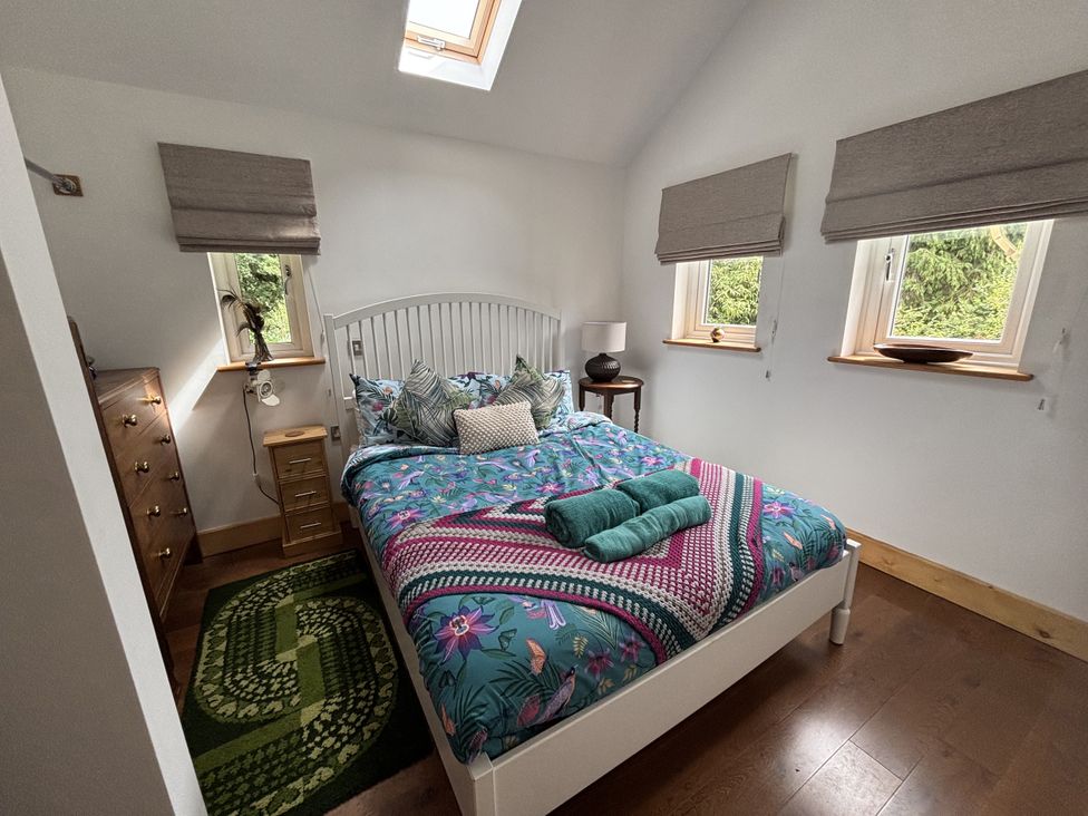 A bedroom with a bed and windows at Delfryn Llandeilo near Llandeilo