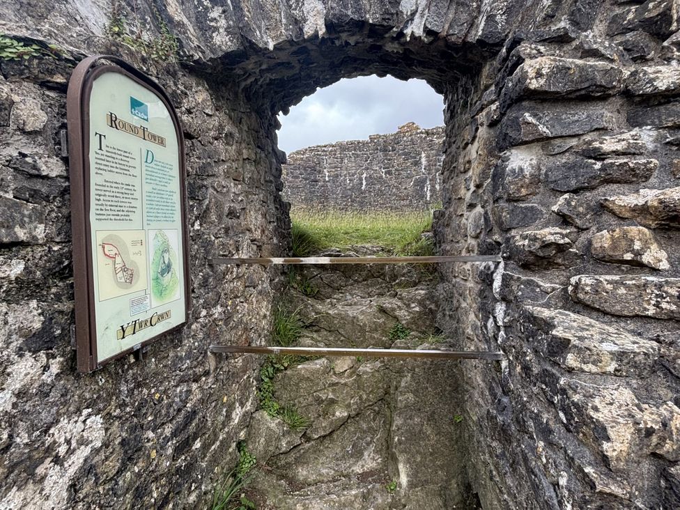 An archway with a stone wall and a sign at the Round Tower near Llandeilo