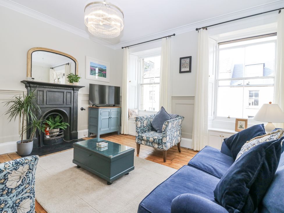 A living room with a sofa and armchair in 11A High Street, Jedburgh