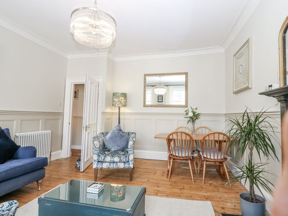 A living room with a sofa and dining set at 11A High Street in Jedburgh