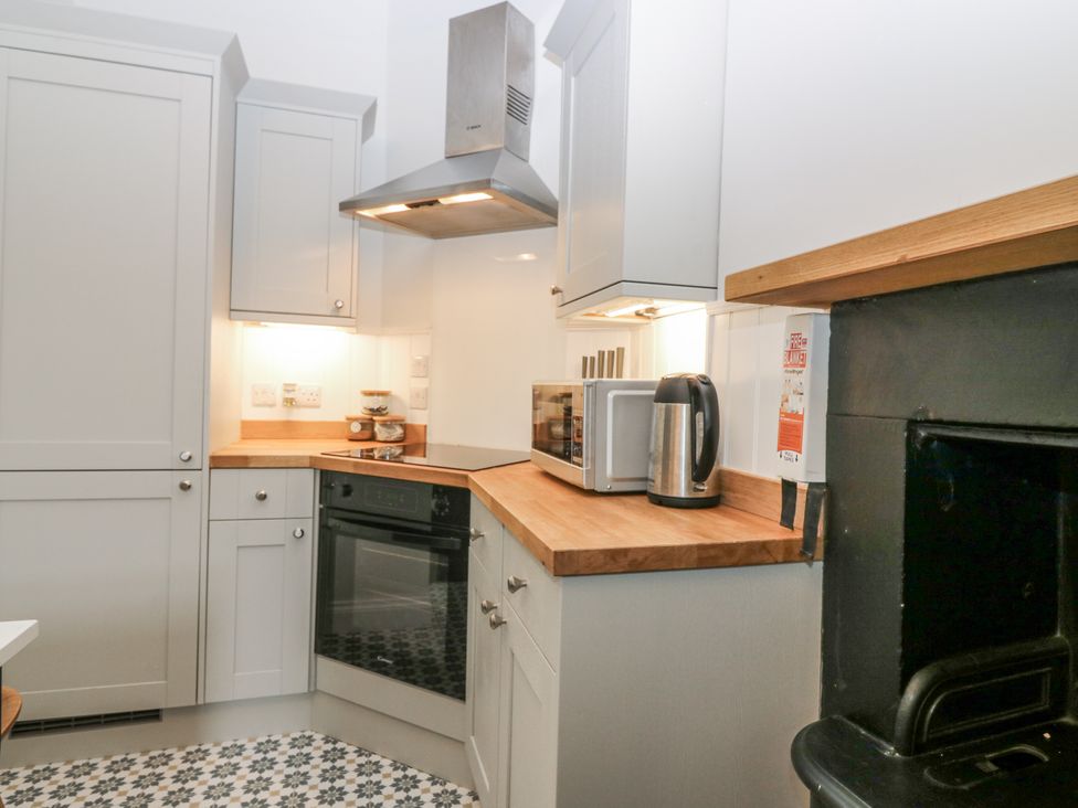 A kitchen with appliances and storage at 11A High Street Jedburgh