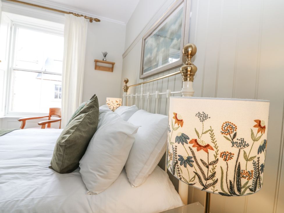 A bedroom with a bed and a lamp at 11A High Street in Jedburgh