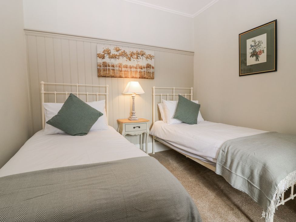 A bedroom with two single beds and a nightstand at 11A High Street, Jedburgh