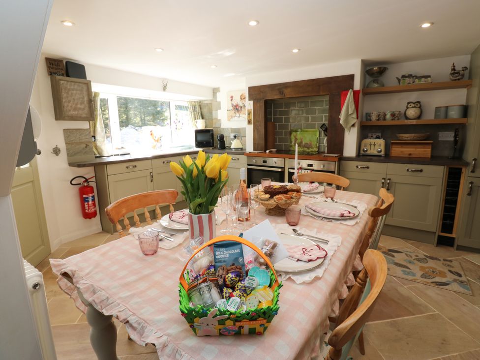 A kitchen with a dining table set and a basket of cookies at The Museum in Nenthead
