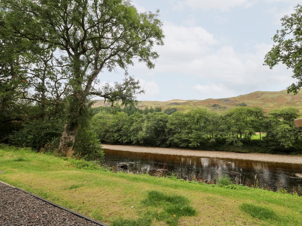 An outdoor scene with a river and trees at Bradan Lodge Dalmally