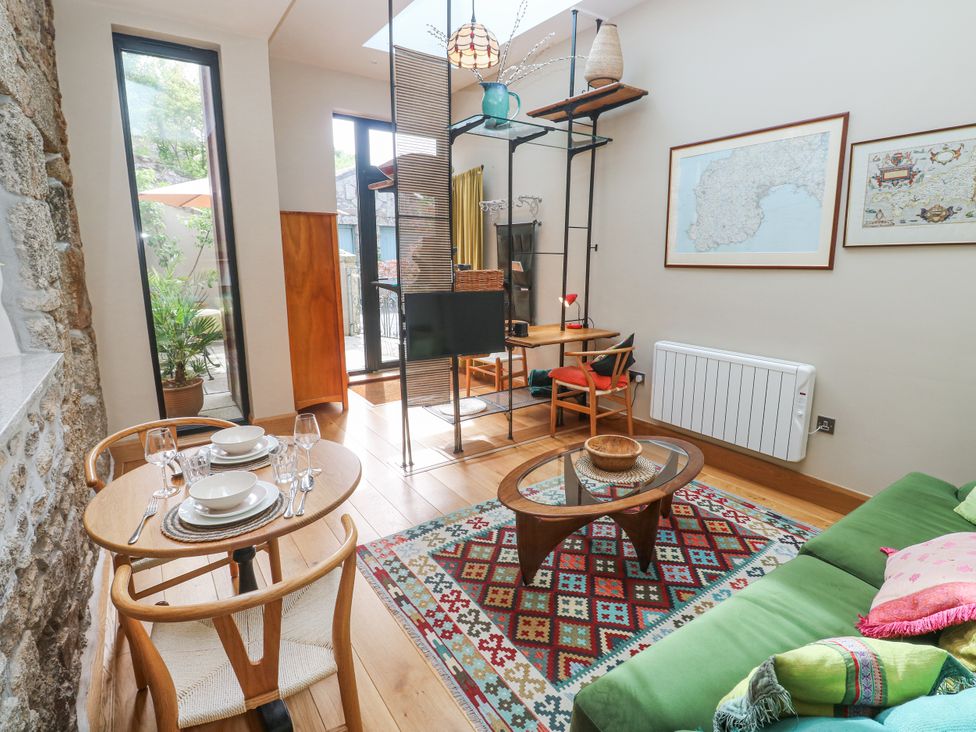 A living room with a dining table and chairs at The Stables in St Just