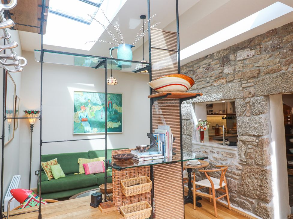 A living room with a green sofa and a painting at The Stables in St Just
