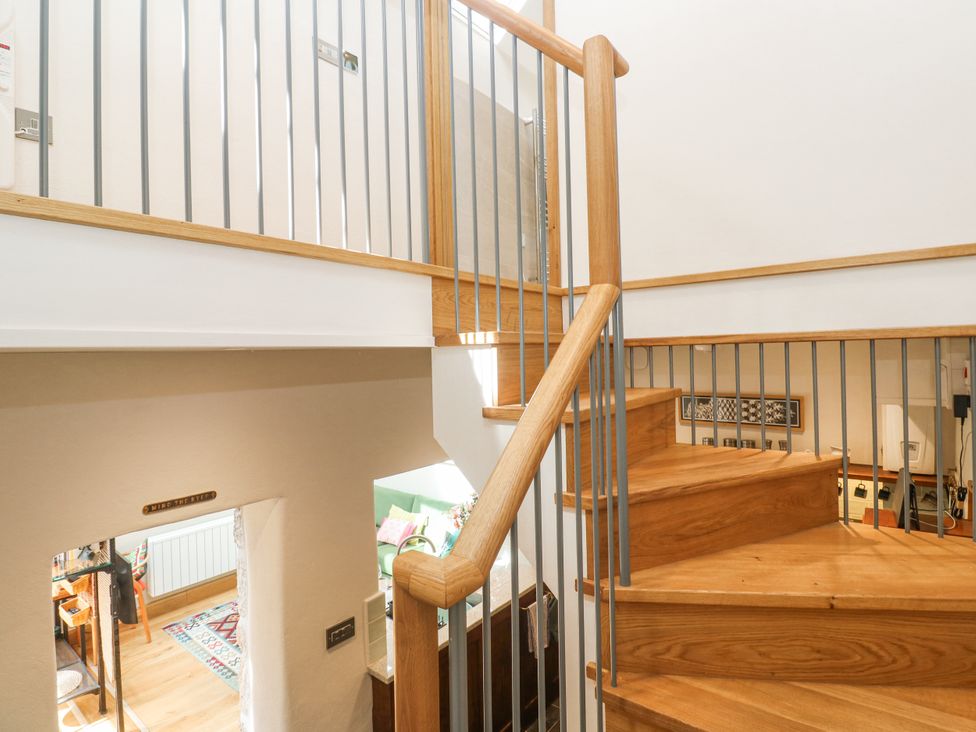 A staircase with a handrail and wall at The Stables in St Just