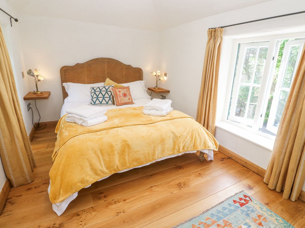 A bedroom with a bed and a window at The Stables in St Just