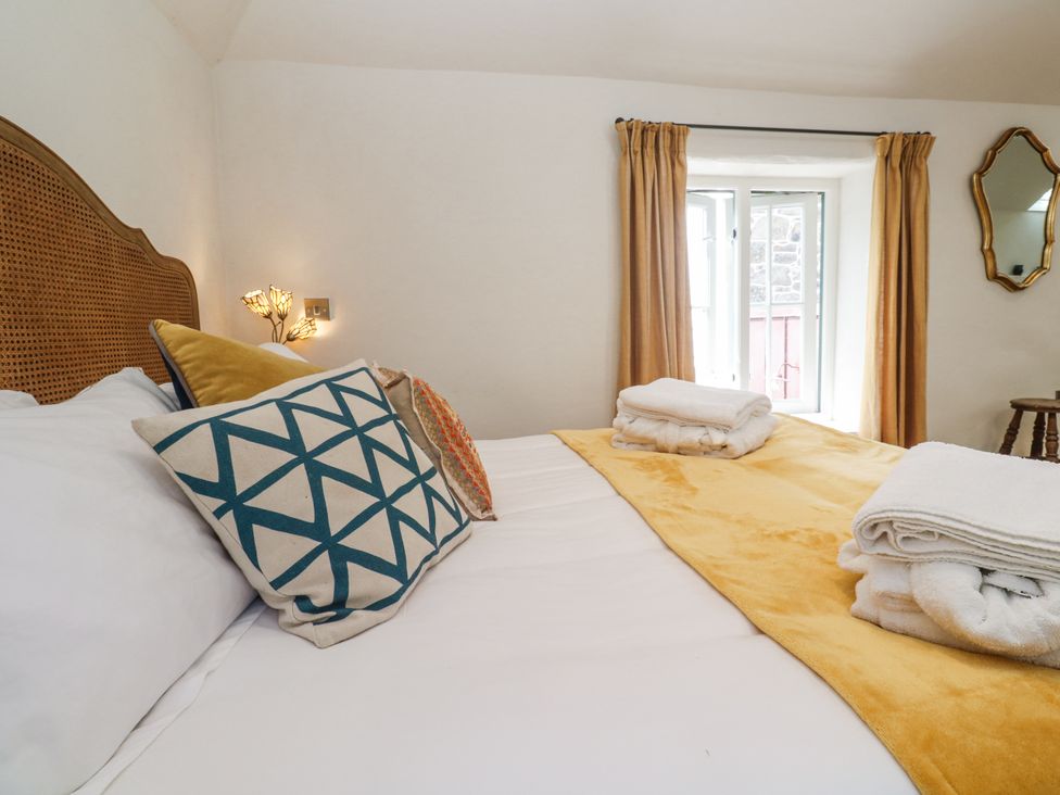 A bedroom with a bed and window at The Stables in St Just