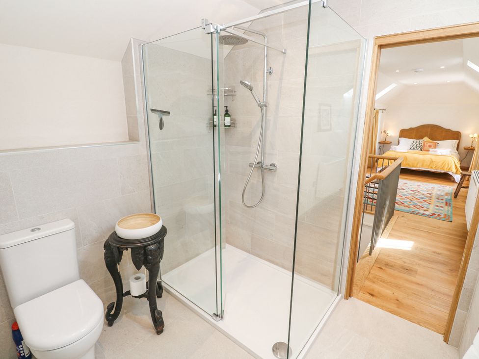 A bathroom with a shower and toilet at The Stables in St Just