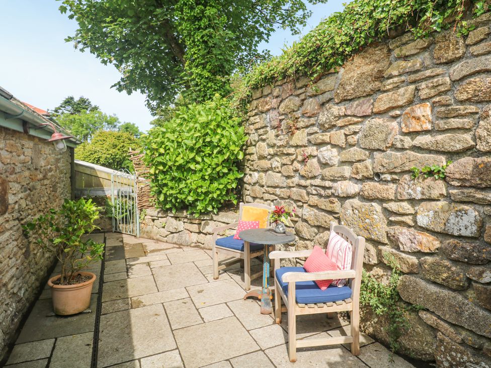 An outdoor area with chairs and a table at The Stables in St Just