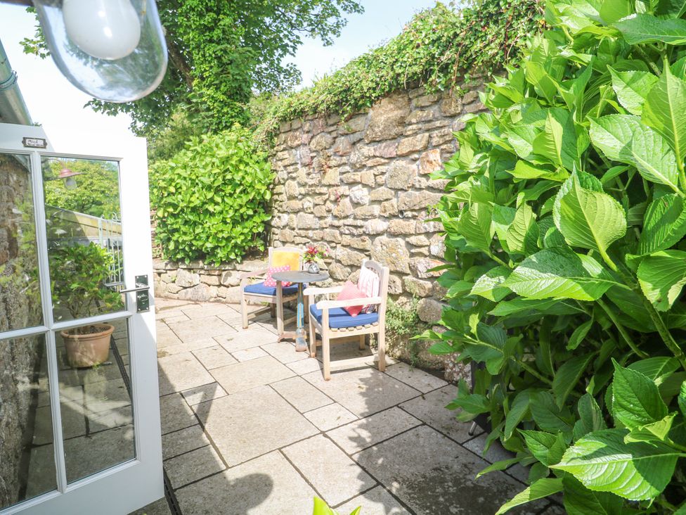 An outdoor seating area with chairs and a table at The Stables in St Just