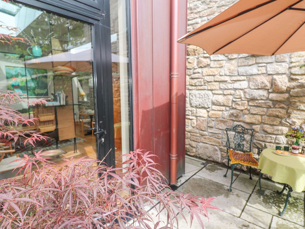 An outdoor seating area with a table and chairs at The Stables in St Just