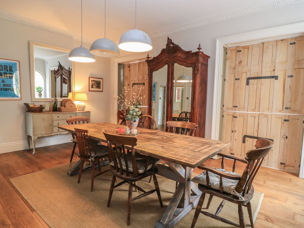 A dining room with a wooden table and chairs at Cotswold House Moreton-In-Marsh
