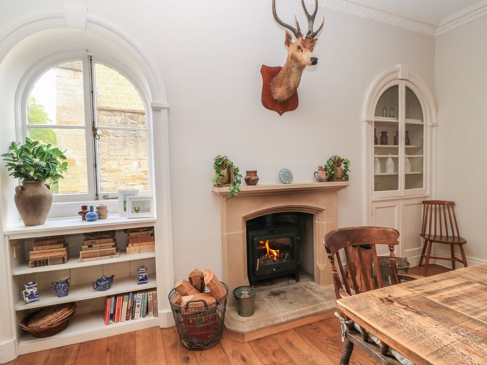 A living room with a fireplace and bookshelf at Cotswold House in Moreton-In-Marsh