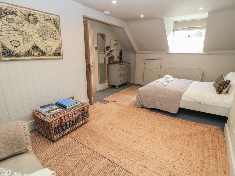 A bedroom with a bed and storage basket at Cotswold House in Moreton-In-Marsh