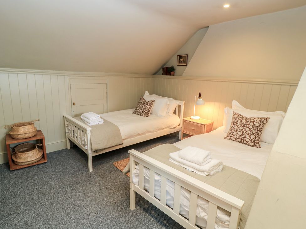 A bedroom with two beds and a lamp at Cotswold House in Moreton-In-Marsh