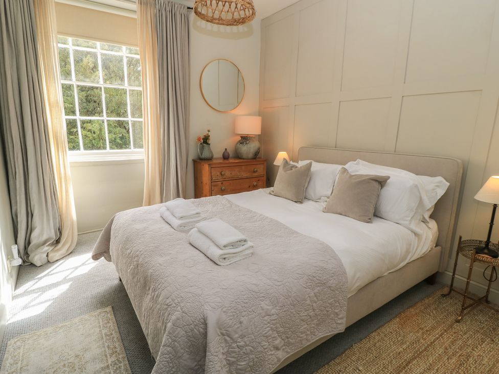 A bedroom with a bed and bedside table at Cotswold House Moreton-In-Marsh