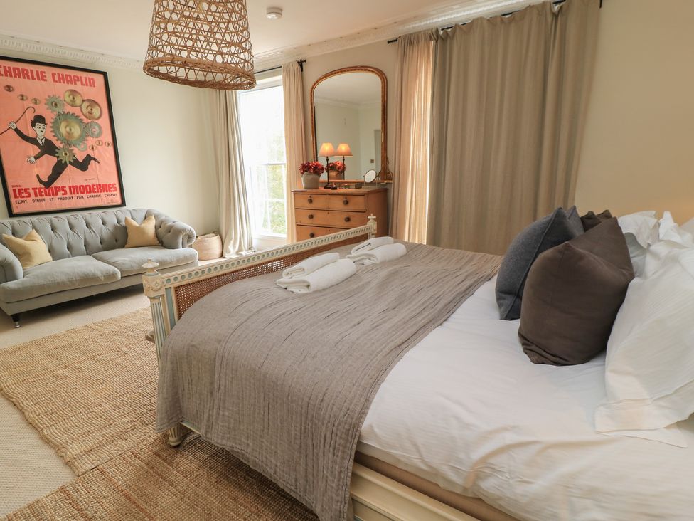 A bedroom with a bed and a sofa at Cotswold House Moreton-In-Marsh