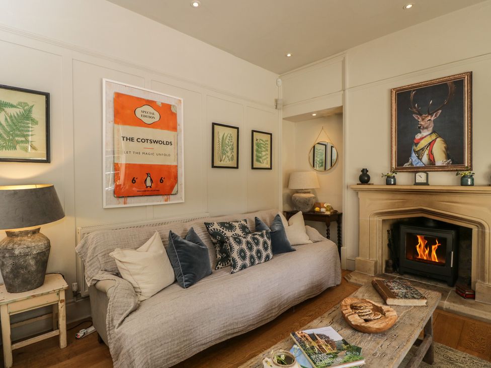 A living room with a sofa, fireplace, and coffee table at Cotswold House in Moreton-In-Marsh