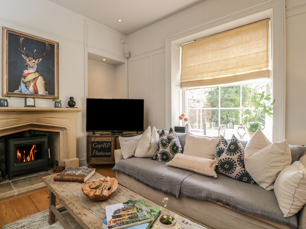 A living room with a sofa and a fireplace at Cotswold House in Moreton-In-Marsh