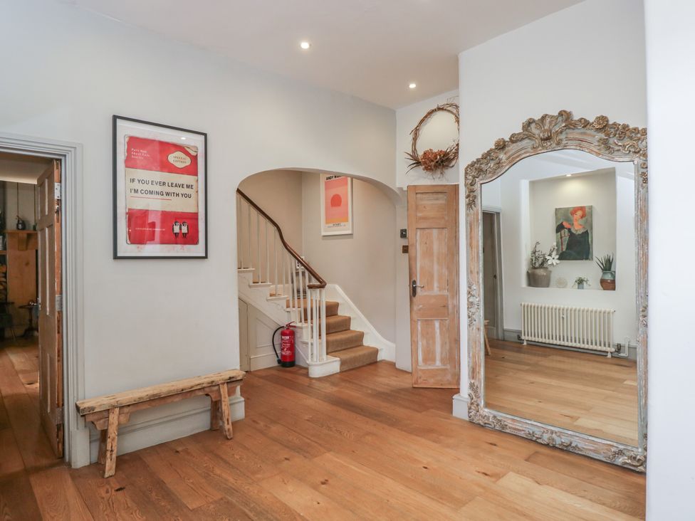 A hallway with a bench and a staircase at Cotswold House Moreton-In-Marsh