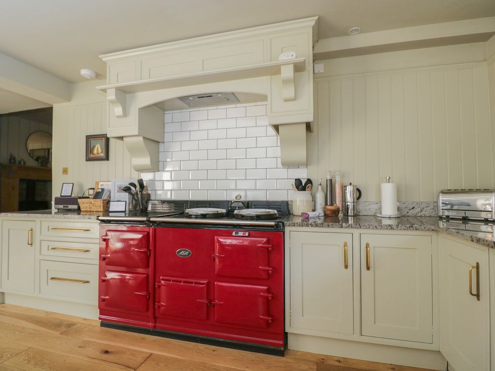 A kitchen with a red cooker and kitchen units at Cotswold House in Moreton-In-Marsh